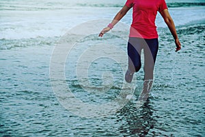 Woman jogging workout on the beach in the morning. Relax with the sea walk. in summer