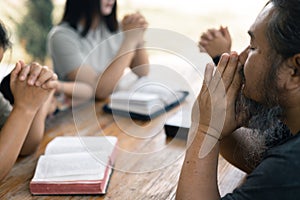 Woman joined hands with her faith group, coming together to pray as a team, unified in their devotion to God and their shared