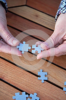 Woman joining two matching puzzle pieces in her hands. Concept of business decisions, teamwork and cooperation