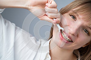 The woman jokingly tightens the wire of the brakes with a wrench. Bite correction device