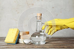 Woman with jug of vinegar and cleaning supplies