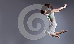 Woman jump. Beauty girl dance on grey background