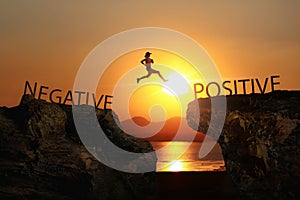 A woman jump through the gap between Negative to Positive on sunset