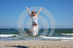 Woman in a jump shot on the beach of the Baltic sea