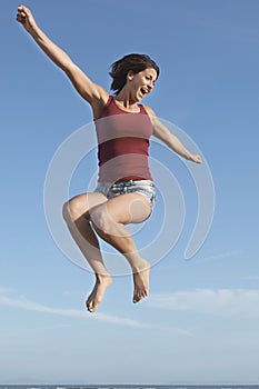 Woman Jumping In Air Against Blue Sky