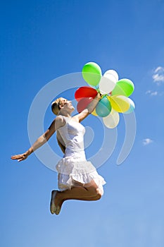 Woman jumping with balloons