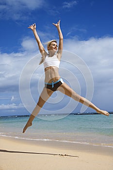 Woman jumping on beach.