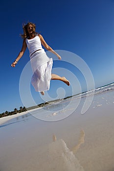 Woman jumping on beach photo