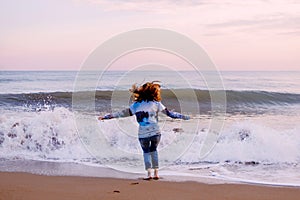 Woman jumping on the beach. Storm, sunset.