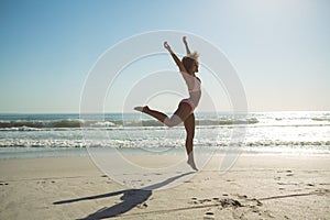 Woman jumping at beach on a sunny day