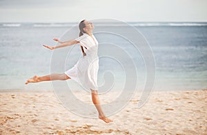 Woman jumping with cloth on a beach