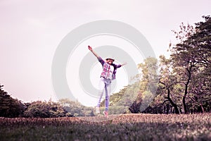 Woman jumping enjoying relax on green grass and flower field in