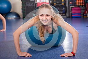 Woman jumping on exercise ball during group train