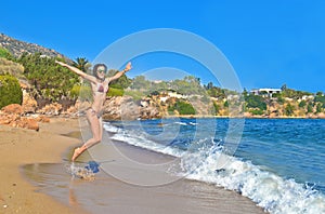 Woman jumping at a greek beach