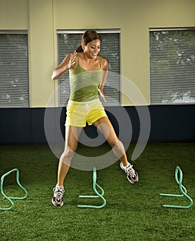 Woman jumping hurdles.