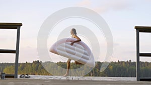 Woman jumping into the lake from wooden pier. Having fun on summer day. Young girl diving in to the water from the dock.