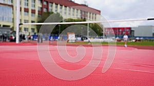 Woman jumping over bar at athletics meeting