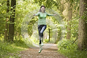 Woman jumping on path smiling