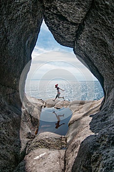 The woman jumping in the pothole over background of blue sea