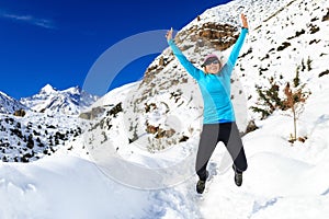 Woman jumping and running in winter mountains