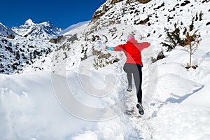 Woman jumping running in winter mountains