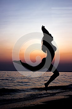 Woman jumping on sand at the sea in sunset. freedom life concept. girl jumping on the beach at the day time