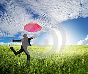 Woman jumping to blue sky with red umbrella