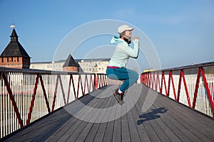 Woman jumping on a wooden bridge, cardio exercise outdoors, taking care of her body, staying healthy and fit