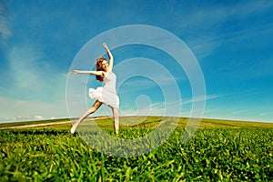 Woman jumping. Young beautiful girl jumping in field on the gra