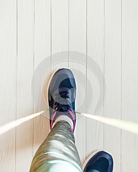 woman jumps rope. top view of female legs in sports sneakers stepping on jump rope