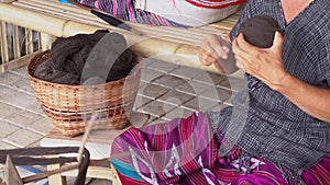 Woman Karen Tribal rolling a ball of brown dyed thread in preparation for hand weaving traditional clothing and crafts