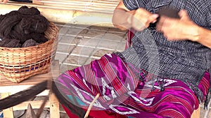 Woman Karen Tribal rolling a ball of brown dyed thread in preparation for hand weaving traditional clothing and crafts