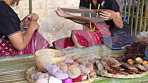 Woman Karen Tribal rolling a ball of brown dyed thread in preparation for hand weaving traditional clothing and crafts