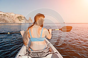 Woman in kayak back view. Happy young woman with long hair floating in kayak on calm sea. Summer holiday vacation and