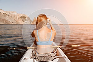 Woman in kayak back view. Happy young woman with long hair floating in kayak on calm sea. Summer holiday vacation and