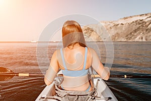 Woman in kayak back view. Happy young woman with long hair floating in kayak on calm sea. Summer holiday vacation and