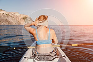 Woman in kayak back view. Happy young woman with long hair floating in kayak on calm sea. Summer holiday vacation and