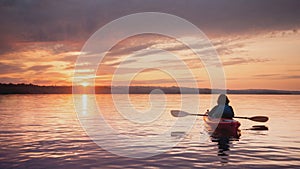 Woman in a kayak on the river on the scenic sunset. Cinemagraph.