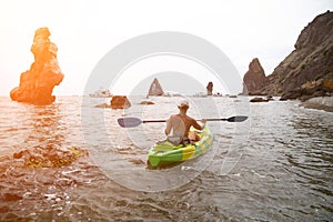 Woman kayak sea. Happy tourist takes sea photo in kayak canoe for memory. Woman traveler poses amidst volcanic mountains