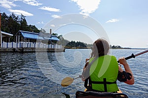 A woman kayaking around Protection Island, visiting a dinghy dock restaurant for a snack, outside Nanaimo, Canada