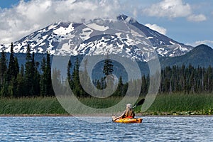 Woman kayaking mountain lake