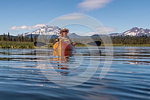 Woman kayaking on mountain lake near Bend, Oregon photo