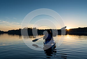 Woman Kayaking at Sunset photo