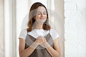 Woman keep both palms on chest express gratitude