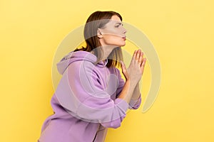 Woman keeping arms in prayer gesture and asking forgiveness, feeling sorry for mistake.
