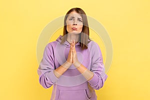 Woman keeping arms in prayer gesture and asking forgiveness, feeling sorry for mistake.