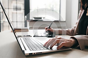 Woman keyboarding on laptop, student work