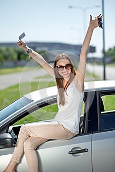 Woman with keys and lisence near her car