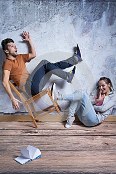 Woman kicking toppling chair photo