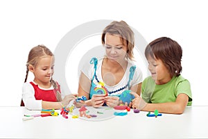 Woman and kids playing with colorful clay photo